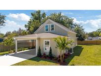 View of home featuring landscaped yard, carport, and neutral-toned exterior at 23 N Edwards St, Plant City, FL 33563
