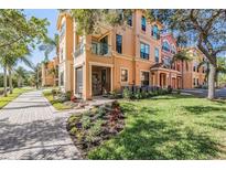 Charming peach-colored townhome with lush landscaping and paver walkway in a desirable community at 2733 Via Cipriani # 814A, Clearwater, FL 33764