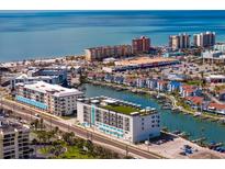 Beautiful aerial view showcasing waterfront community with beach access and modern condominium building at 400 150Th Ave # 206, Madeira Beach, FL 33708