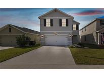 Two-story home boasts a wide driveway and a modern gray facade with black shutter accents at 4727 Lindever Ln, Palmetto, FL 34221