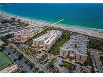Stunning aerial view of beachfront condos, showcasing the pristine beach and turquoise ocean waters at 6500 Sunset Way # 501, St Pete Beach, FL 33706