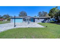 Charming single-story home featuring a colorful facade, paved driveway, well-manicured lawn, and decorative fountain at 1111 Durant Rd, Brandon, FL 33511