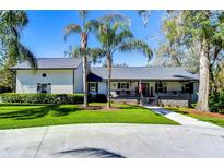 Charming home features a well-manicured lawn, mature landscaping, and welcoming front porch at 11524 River Country Dr, Riverview, FL 33569