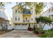 Charming two-story yellow home with a balcony and two-car garage at 476 Rebstock Blvd, Palm Harbor, FL 34683