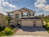 Stunning two-story home featuring a three-car garage and stone accents at 3150 Marine Grass Dr, Wimauma, FL 33598