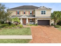 Beautiful two-story home featuring a brick driveway and well-maintained lawn at 3667 Arbor Chase Dr, Palm Harbor, FL 34683