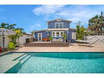 Inviting backyard with pool, lounge area, grilling station, and hammock for relaxation under the bright blue sky at 3727 38Th N St, St Petersburg, FL 33713