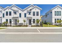 New townhome with white exterior, black accents, and a well-maintained front yard with a black metal fence at 7213 Sutton Ln, Sarasota, FL 34240