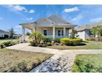 Charming single-story home with a welcoming front porch, lush landscaping, and a well-manicured lawn at 729 Winterside Dr, Apollo Beach, FL 33572