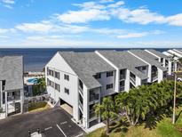 Coastal condo building features assigned parking, community pool, and partial Gulf views at 808 Bahia Del Sol Dr # 14, Ruskin, FL 33570