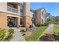 Exterior view of a multi-story building with a patio, walkway, and landscaped grounds at 10405 Villa View Cir # 10405, Tampa, FL 33647