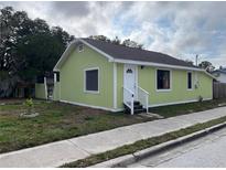Charming home featuring a white front door, a bright green exterior and neat landscaping at 1554 Tilley Ave, Clearwater, FL 33756