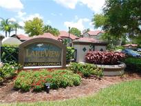 Landscaped entrance to Lakeview at Calusa Trace luxury condominiums with a decorative sign and manicured foliage at 18106 Peregrines Perch Pl # 5208, Lutz, FL 33558