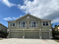 Three-story townhome featuring a three-car garage and balconies with white railings at 27901 Pleasure Ride Loop, Wesley Chapel, FL 33544