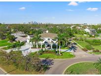 Stunning two-story home boasts lush landscaping, a circular driveway, and a picturesque cityscape backdrop at 866 S Davis Blvd, Tampa, FL 33606