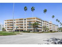 Low angle shot of a multi-story condo building with balconies and palm trees on a sunny day at 1200 N Shore Ne Dr # 110, St Petersburg, FL 33701