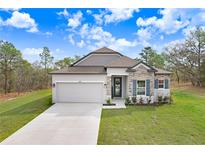 Charming one-story home featuring stone accents, gray shutters, and a two-car garage, nestled on a well-maintained lawn at 16394 Scaup Duck Ave, Weeki Wachee, FL 34614