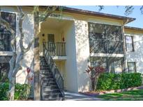 Two-story condo building with stair access to the upper units and well-maintained landscaping at 3367 Crystal E Ct # F, Palm Harbor, FL 34685