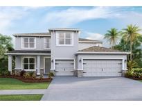 Two story home featuring a gray exterior, a two car garage, a manicured lawn, and tasteful landscaping at 3422 Hazel Hollow Way, Plant City, FL 33565