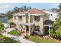 Charming two-story home featuring a well-manicured lawn, a two-car garage, and inviting front porch at 3900 W Platt St, Tampa, FL 33609