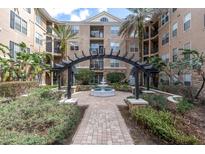 Beautiful courtyard featuring a fountain, lush landscaping, and an elegant pergola at 4221 W Spruce St # 1407, Tampa, FL 33607