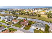 Aerial view of a suburban home with a large backyard, canal, and waterfront community in the distance at 811 Eagle Ln, Apollo Beach, FL 33572