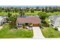 Inviting single-story home featuring lush landscaping, a well-maintained lawn, and a charming front entrance with a 2 car garage at 811 Eagle Ln, Apollo Beach, FL 33572