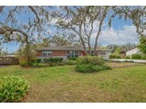 Charming single-story brick home with a well-maintained lawn and mature trees at 11103 Hannaway Dr, Riverview, FL 33578