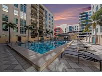 Resort style community pool with lounge chairs, cabana and beautiful tropical landscaping at 1238 E Kennedy Blvd # 704, Tampa, FL 33602