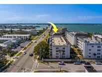 Aerial view of condo building with waterfront access, parking, and an ideal location near the beach and intercostal waterway at 131 Bluff View Dr # 208, Belleair Bluffs, FL 33770