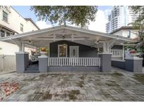 Charming craftsman style bungalow with a spacious front porch and a gray brick driveway at 2921 W El Prado Blvd, Tampa, FL 33629