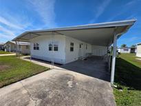 Charming single-story home featuring a covered parking area and well-maintained landscaping at 5403 Comanche St, Zephyrhills, FL 33542