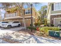 Inviting two-story townhome featuring a balcony, a one-car garage and a beautifully landscaped front yard at 7001 Interbay Blvd # 181, Tampa, FL 33616