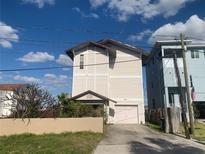 Two-story home featuring a private driveway and a charming covered entryway with lush landscaping at 13253 Boca Ciega Ave, Madeira Beach, FL 33708