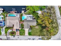 Waterfront home featuring a private pool, boat dock, lush landscaping, and ample parking at 1389 47Th Ne Ave, St Petersburg, FL 33703