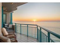 Spacious balcony showcasing ocean views, with a table and chairs for outdoor dining and relaxation at 1560 Gulf Blvd # 1202, Clearwater Beach, FL 33767