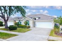 Charming single-story home featuring a two-car garage, well-manicured landscaping, and inviting curb appeal at 2166 Andrews Ct, Dunedin, FL 34698