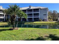 Beautiful condo complex with metal roof, screened balconies, and lovely water feature with fountains and palm trees at 2210 Vista Del Sol Cir # 519, Lutz, FL 33558