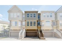 Townhome exterior featuring a private one car garage, stairs to the front door, and muted beige color palette at 4339 Spinnaker Cove Ln, Tampa, FL 33615