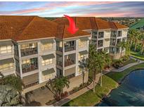 Three-story waterfront condo featuring balconies, neutral paint, and a terracotta-colored tile roof at 1026 Bellasol Way # 4403, Apollo Beach, FL 33572