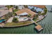 Aerial view of a waterfront home with a private pool, boat dock and lift at 11697 Grove St, Seminole, FL 33772