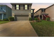 Charming home featuring a two-car garage, tidy landscaping, and a welcoming, neutral-toned exterior at 16549 Secret Meadow Dr, Odessa, FL 33556