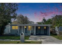 Charming single-story home featuring a carport, well-maintained lawn, and inviting front porch under a colorful sky at 1940 N Betty Ln, Clearwater, FL 33755