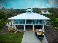Unique waterfront home featuring elevated construction and a large metal roof at 406 Shore W Dr, Oldsmar, FL 34677