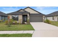 Charming single-story home featuring a well-maintained lawn and a two-car garage at 6127 164Th E Ave, Parrish, FL 34219