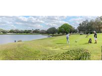 Beautiful golf course view with a golfer and a lake along the fairway on a sunny day at 9376 French Quarters Cir, Weeki Wachee, FL 34613