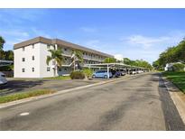 Exterior view of condo complex with covered parking and well maintained grounds in a sunny locale at 9815 47Th N Ave # 303, St Petersburg, FL 33708