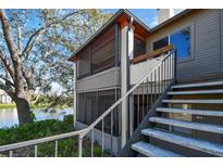 Condo building exterior with stairs leading up to the units and a glimpse of the lake at 10263 Gandy N Blvd # 2014, St Petersburg, FL 33702