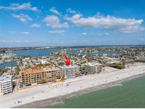 Expansive aerial view of beachfront condo with sandy beach, blue ocean, and beautiful intercoastal waterways at 14700 Gulf Blvd # 405, Madeira Beach, FL 33708