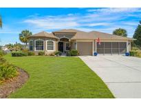 Charming home featuring a well-manicured lawn, a screened three-car garage, and attractive landscaping at 182 Dahoon Ct, Spring Hill, FL 34609